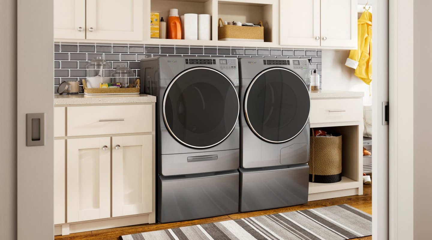 Front load Whirlpool® Washer and Dryer pair on pedestals in a laundry room Front load Whirlpool® Washer and Dryer pair on pedestals in a laundry room