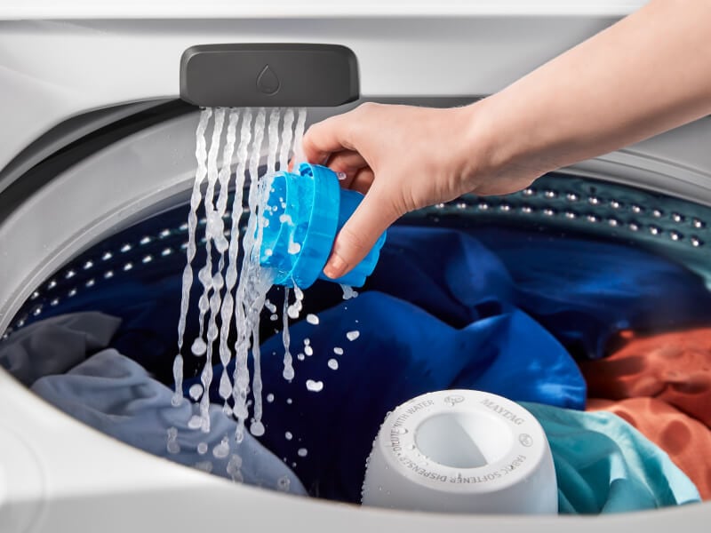 Person pouring detergent in washing machine Person pouring detergent in washing machine