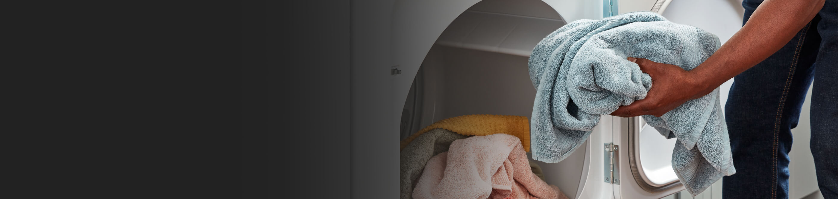 Person loading towel in dryer