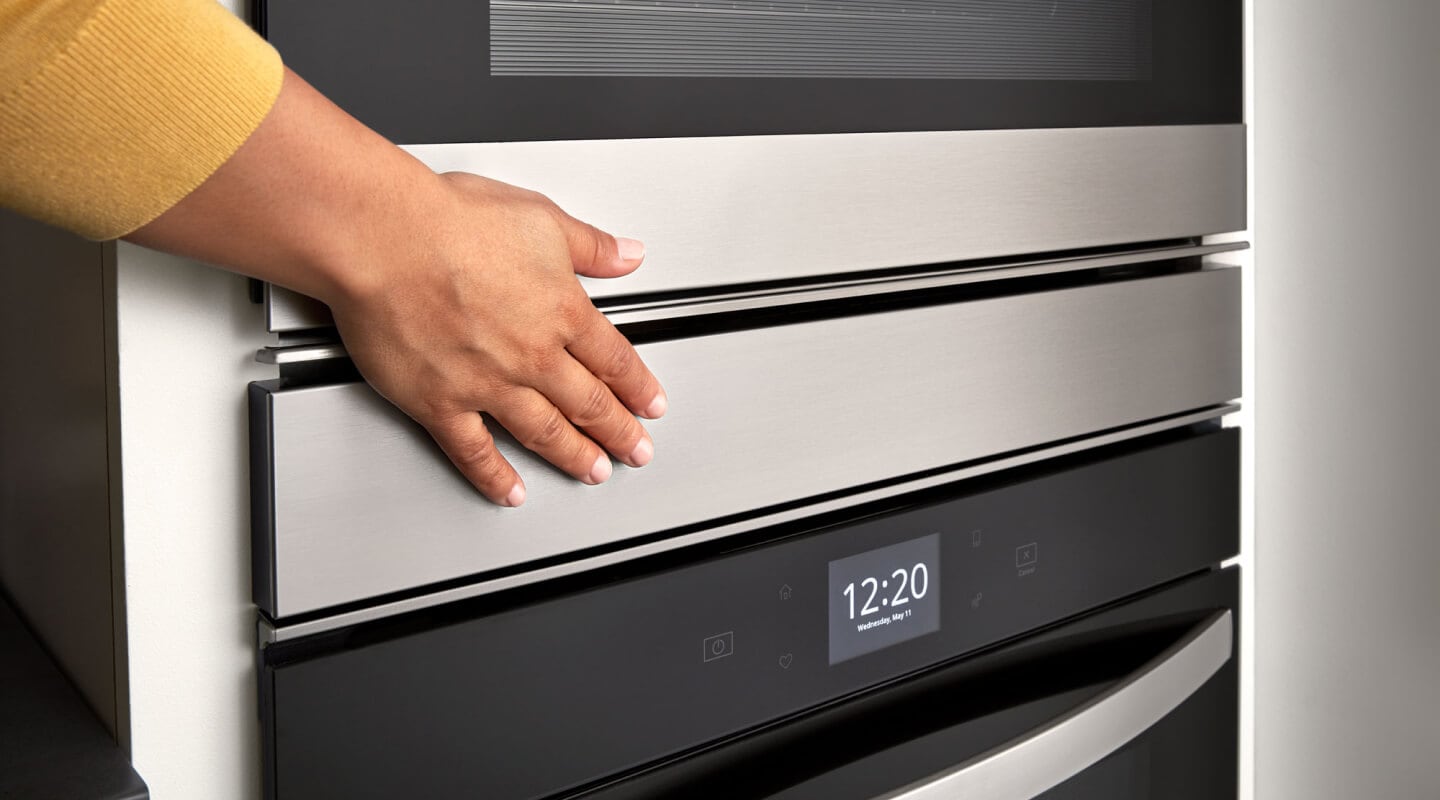 Hand touching a Whirlpool® double wall oven Hand touching a Whirlpool® double wall oven