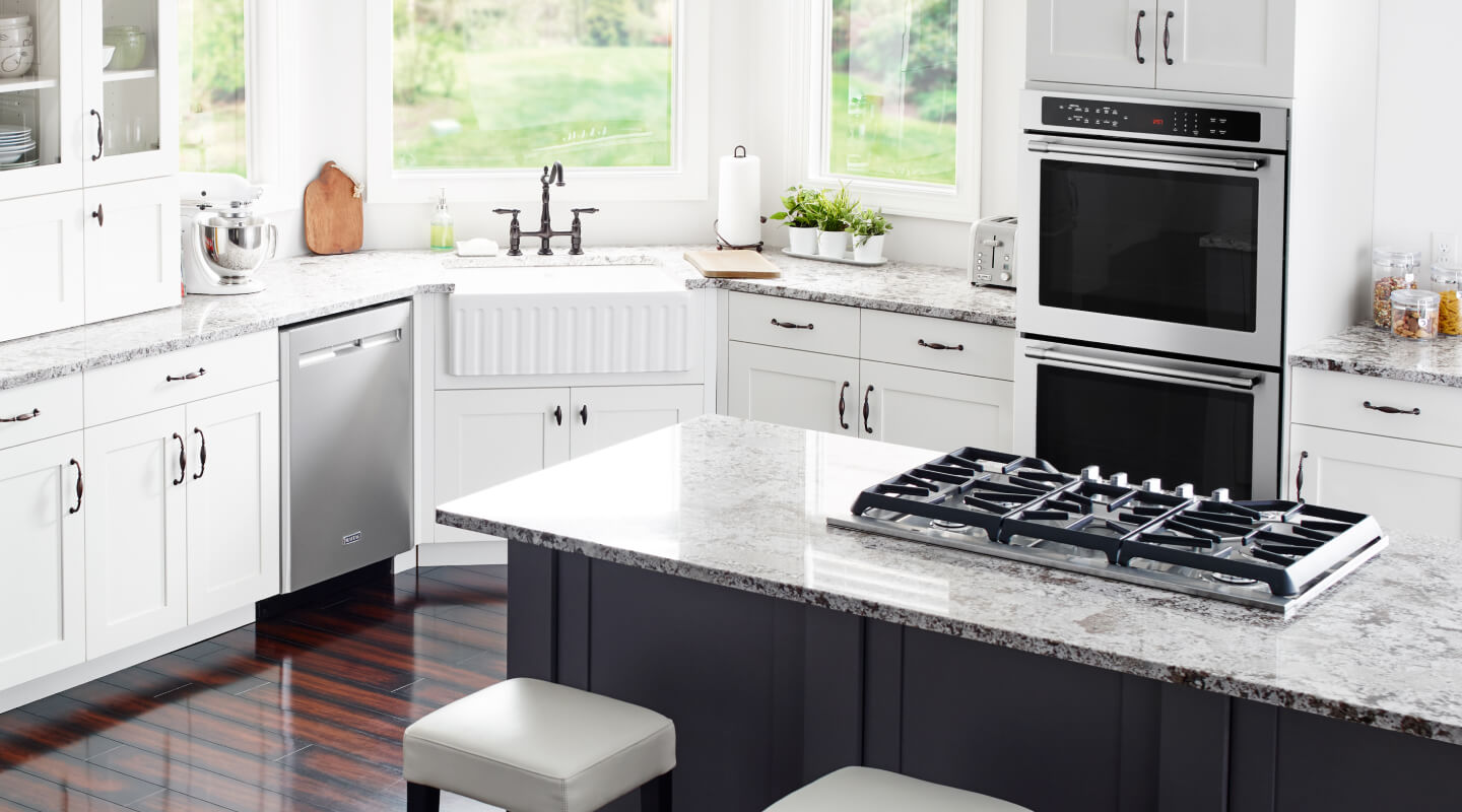 Cooktop in an island with Whirlpool® stainless steel appliances in the background