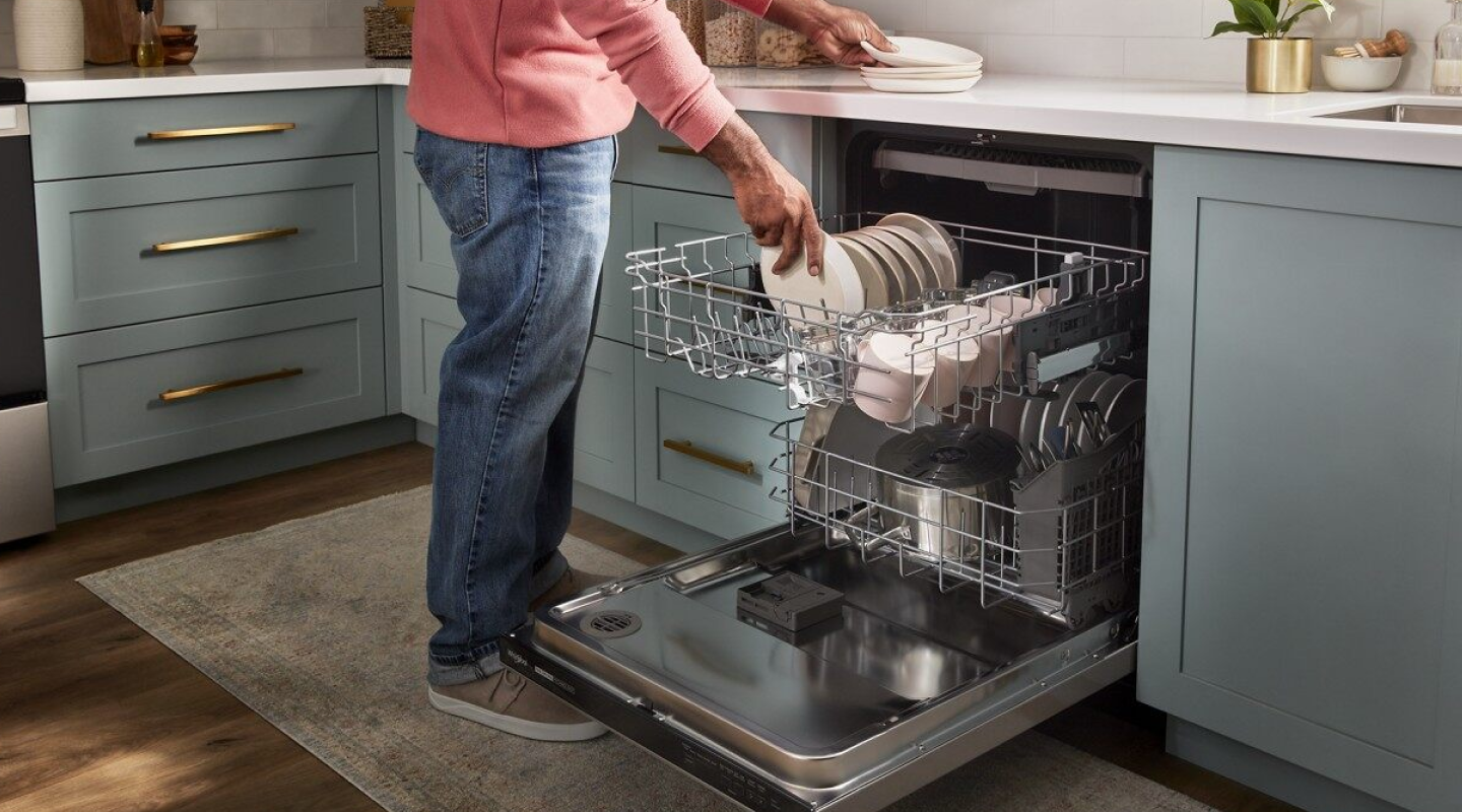A person loading dishes into a dishwasher A person loading dishes into a dishwasher