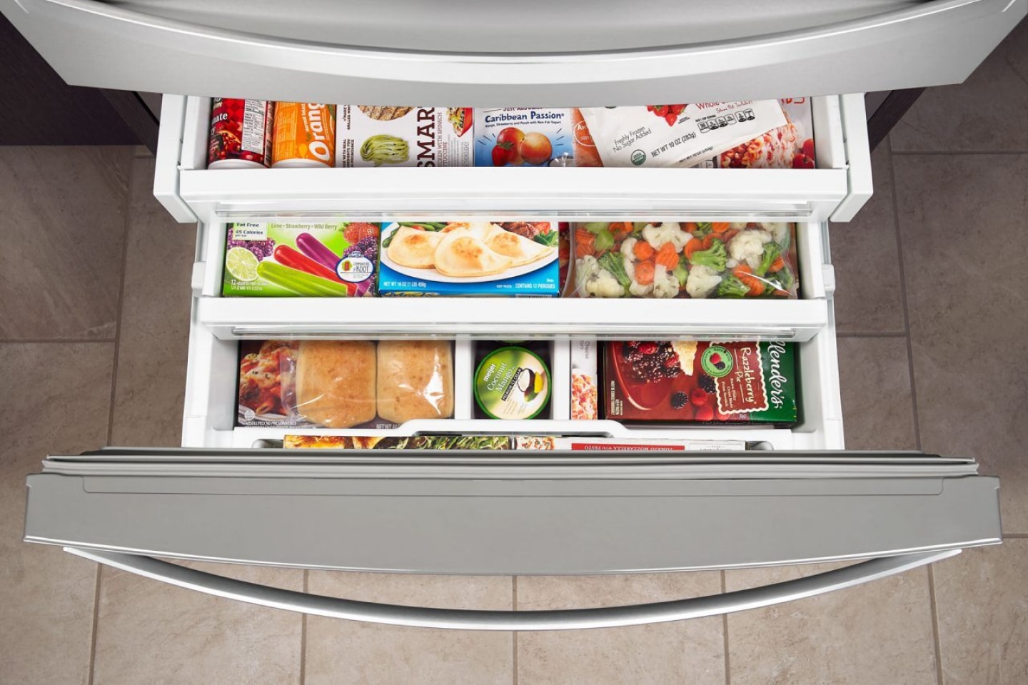Birds-eye view of tiered shelving holding frozen goods in a bottom freezer Birds-eye view of tiered shelving holding frozen goods in a bottom freezer