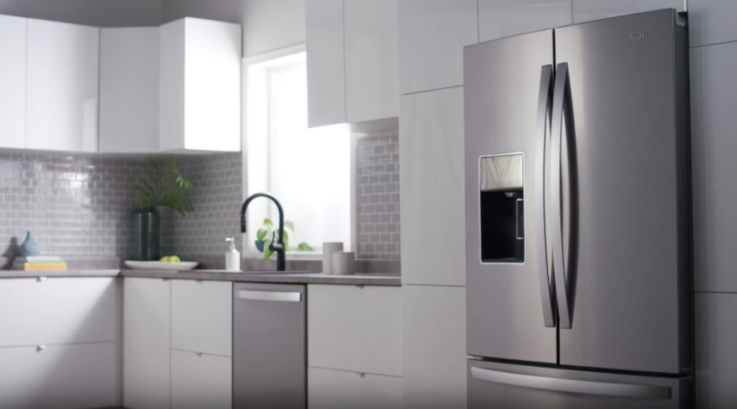 Stainless steel Whirlpool® French door refrigerator in light gray cabinetry