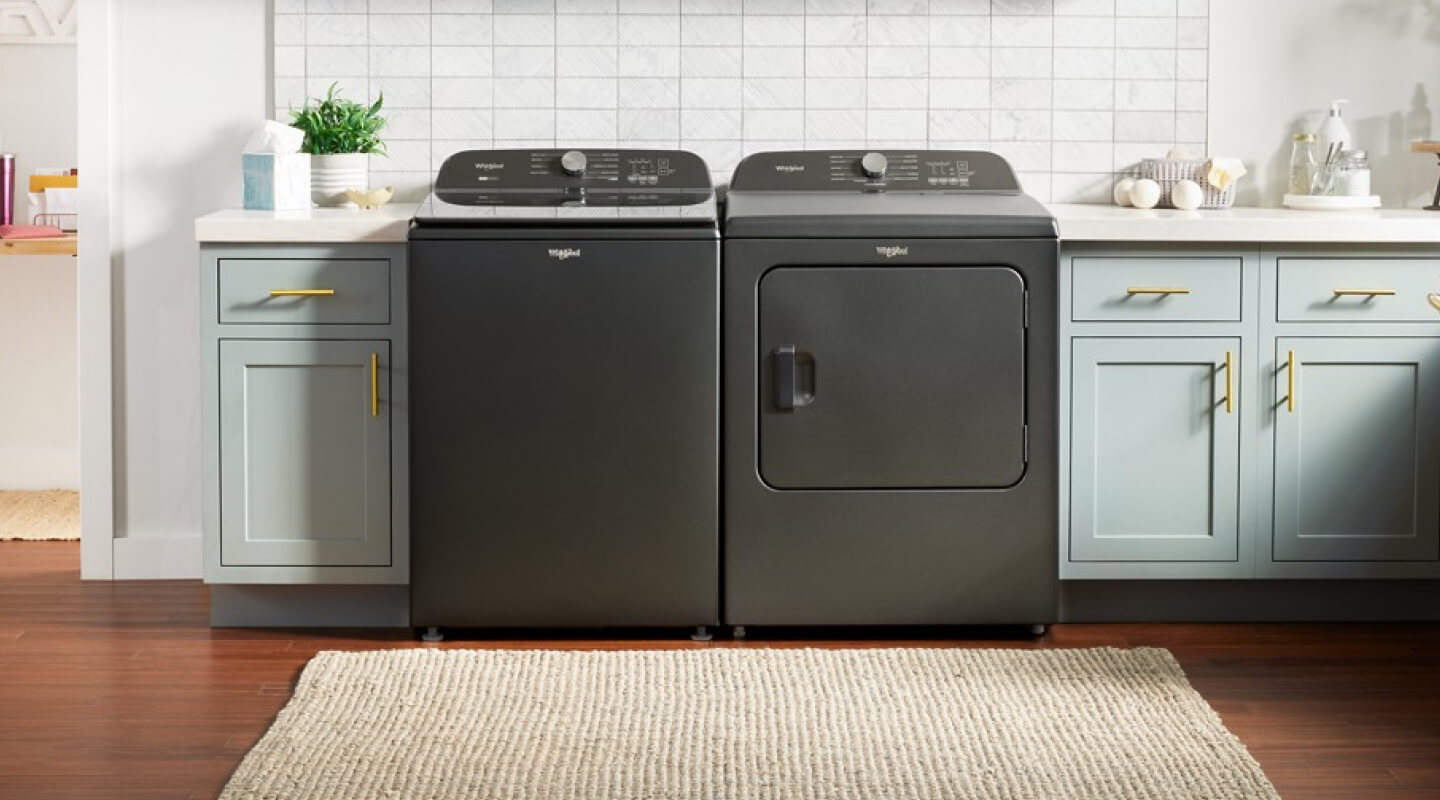 Gray Whirlpool® Top Load Washer and Dryer pair in light blue cabinetry