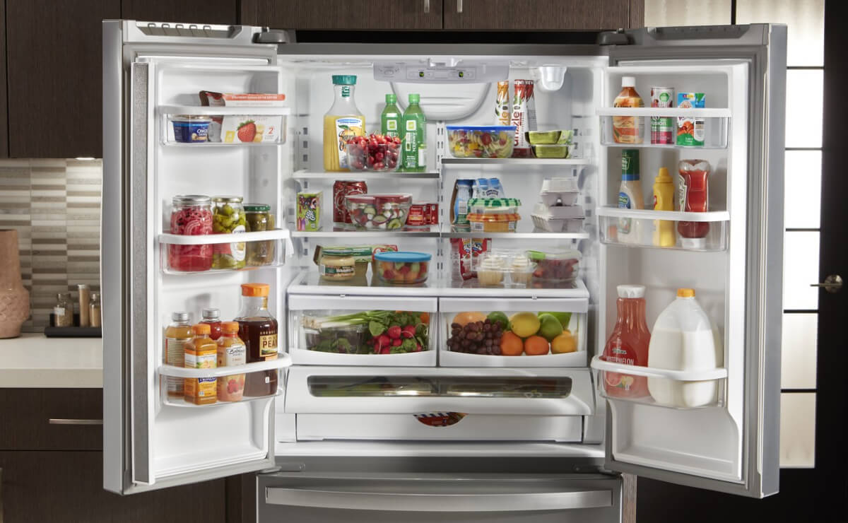 Side-by-side refrigerator doors open with a mix of colorful groceries inside