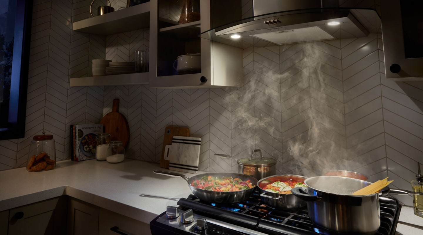 A range hood drawing up smoke from various dishes A range hood drawing up smoke from various dishes