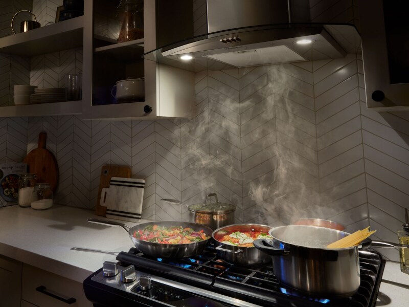 A range hood drawing up smoke from various dishes A range hood drawing up smoke from various dishes