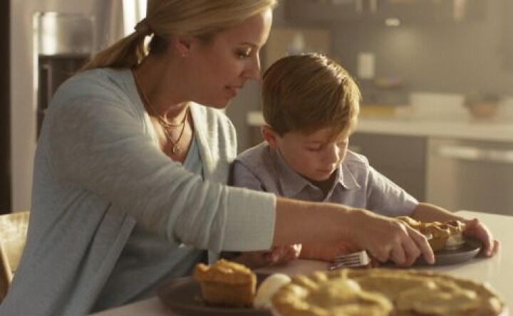 A mom serving her son a slice of pie