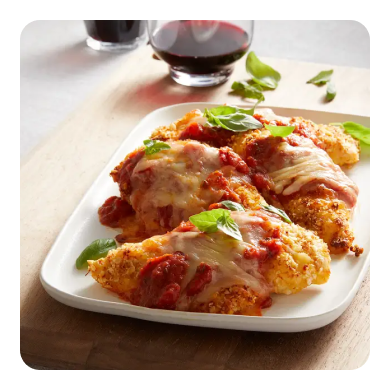 Breaded chicken cutlets on a plate topped with red sauce, cheese and basil Breaded chicken cutlets on a plate topped with red sauce, cheese and basil