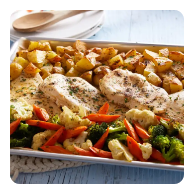 Chicken breasts, a vegetable medley and potatoes on a sheet pan