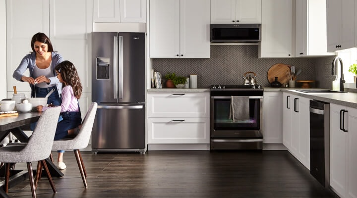 White kitchen featuring Whirlpool® Appliances in stainless steel