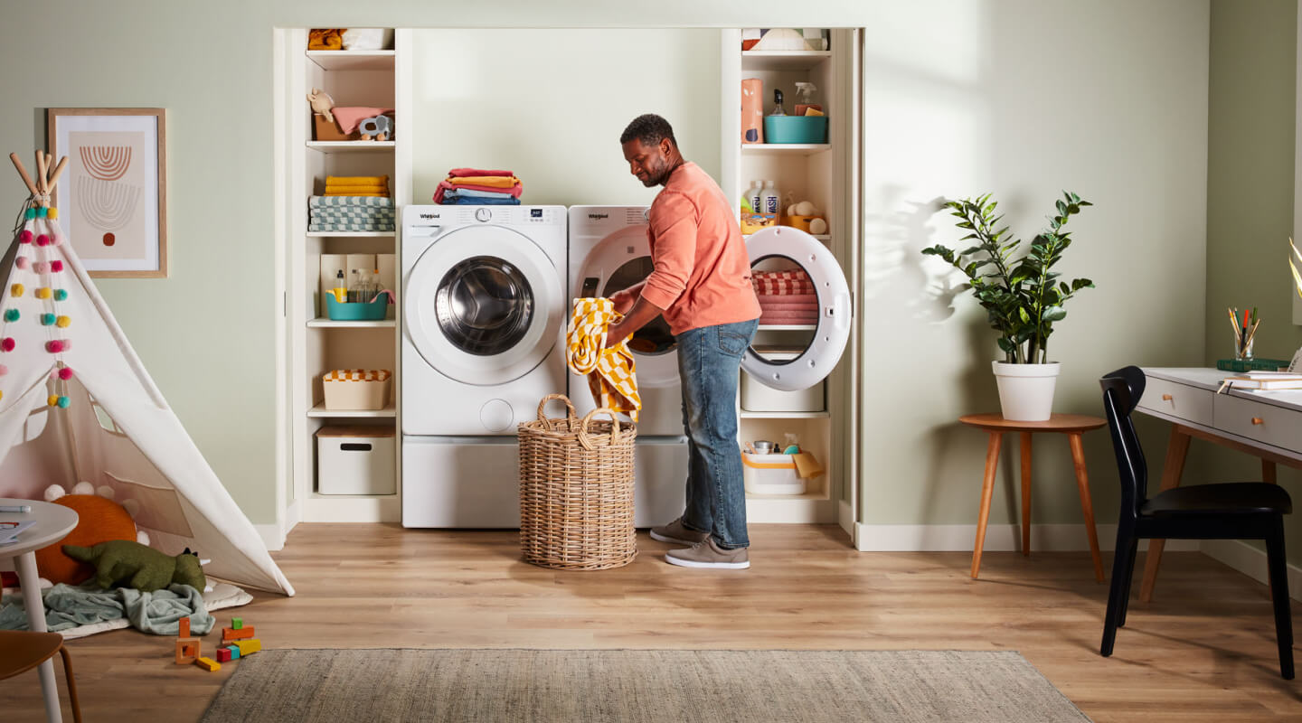 A person pulling clothes out of a dryer A person pulling clothes out of a dryer
