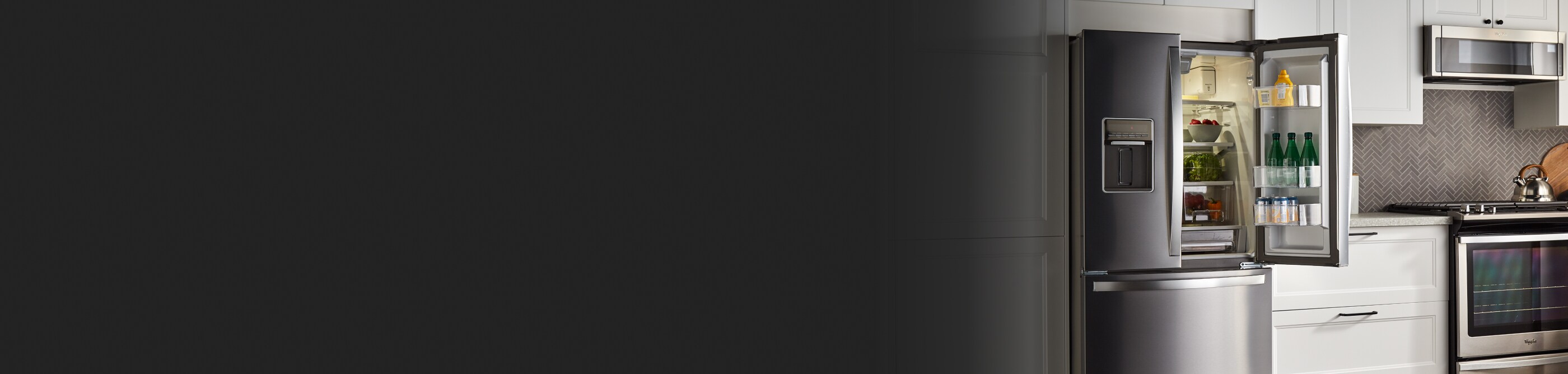 Whirlpool brand French-door refrigerator in white cabinetry with one door open