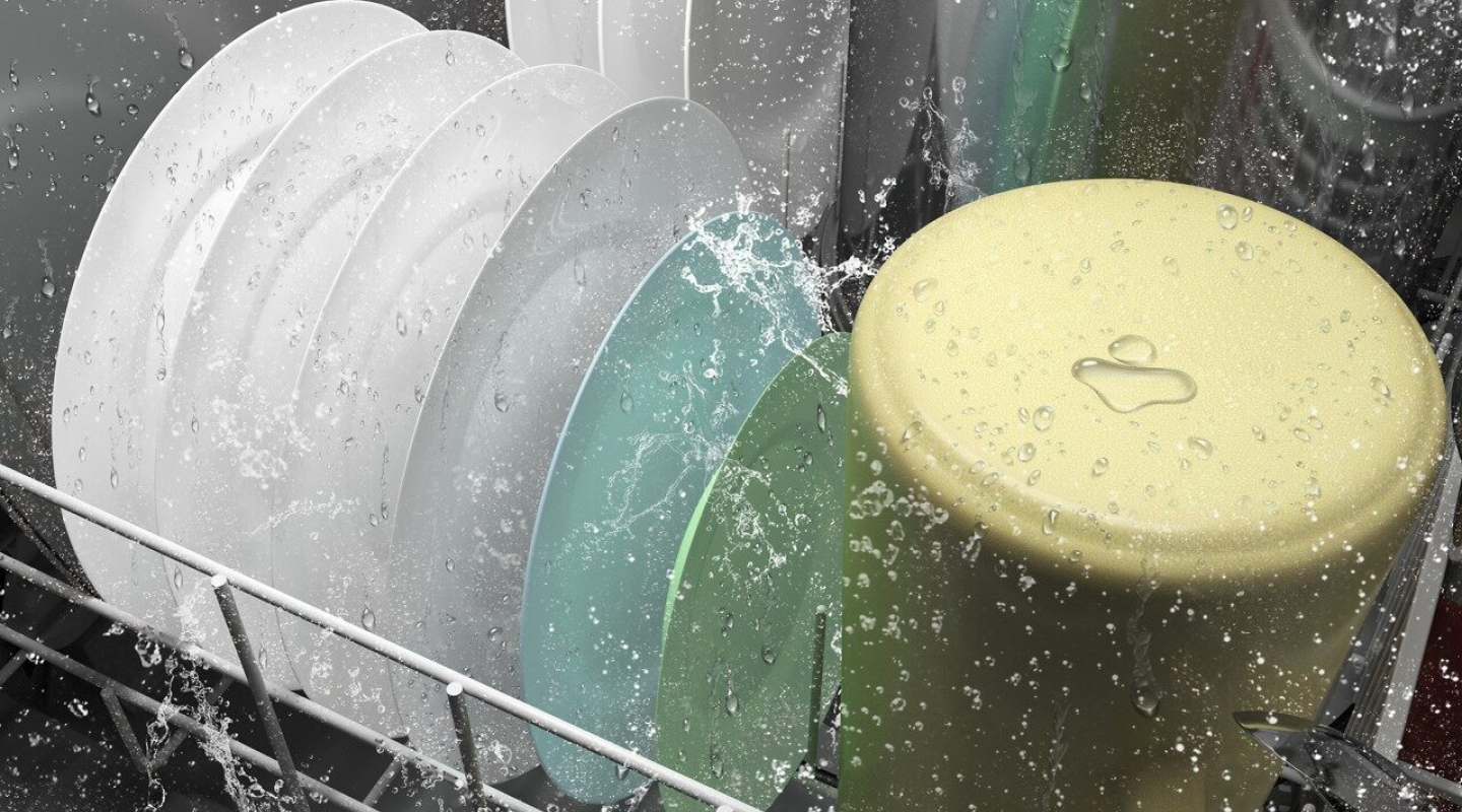 A closeup of the bottom rack of a Whirlpool® dishwasher washing dishware during a wash cycle. A closeup of the bottom rack of a Whirlpool® dishwasher washing dishware during a wash cycle.