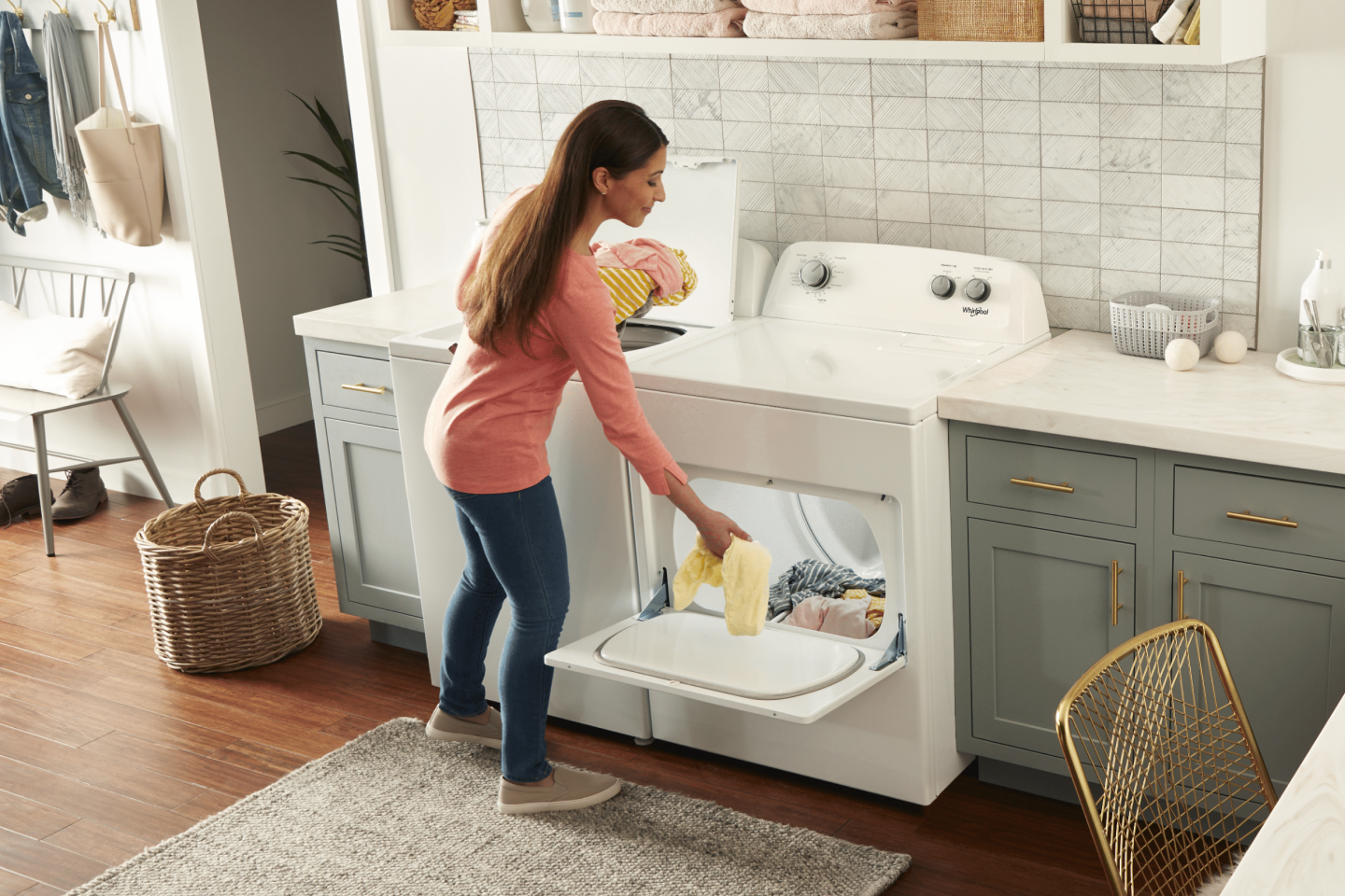 Person placing clothes into a Whirlpool® front load dryer. Person placing clothes into a Whirlpool® front load dryer.