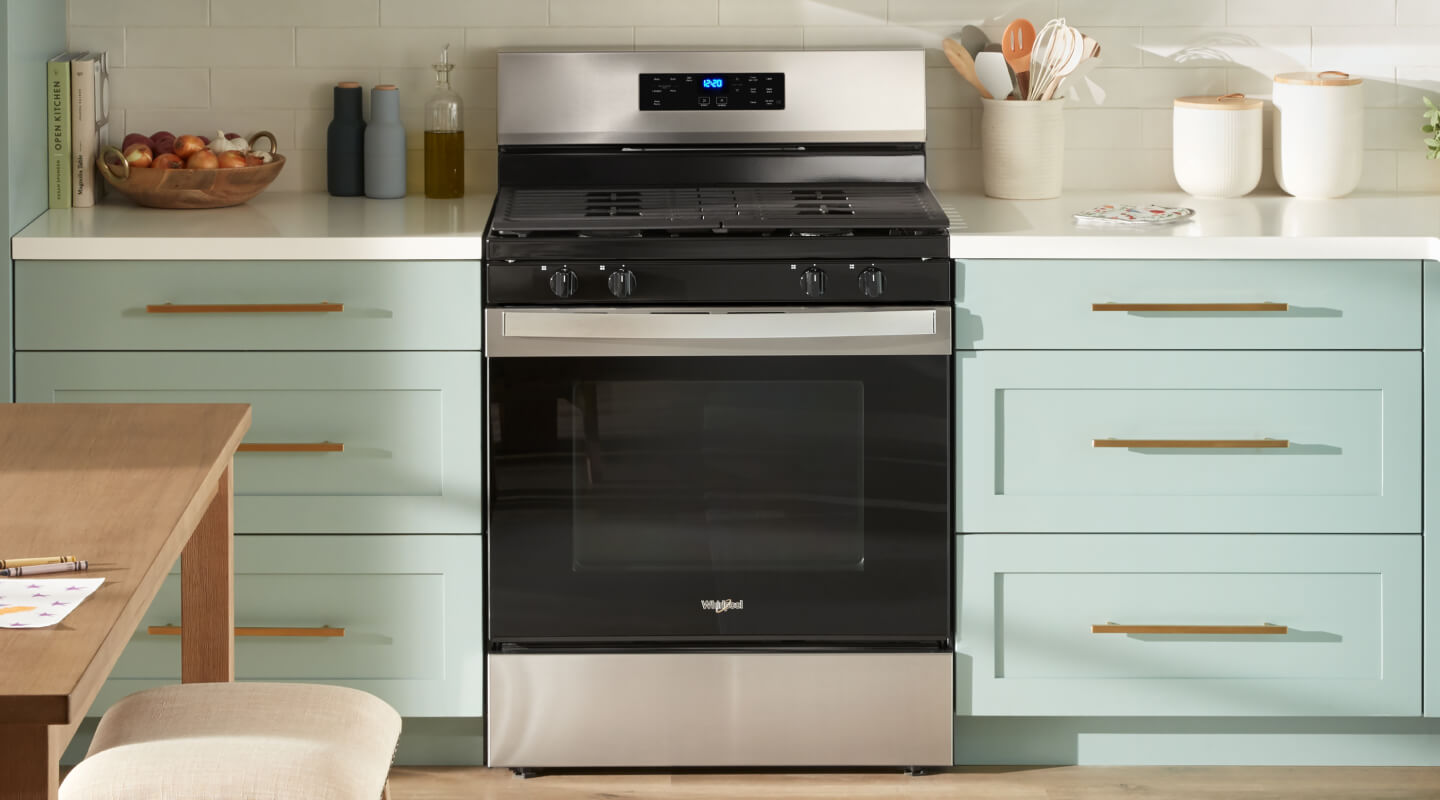A Whirlpool® Gas Range in a kitchen with light green cabinetry