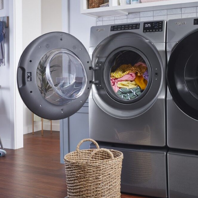 Laundry basket in front of an open Whirlpool® front load washer