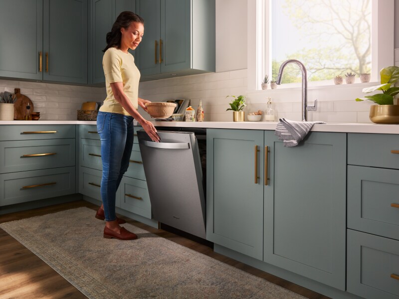 Person closing a Whirlpool® top control dishwasher