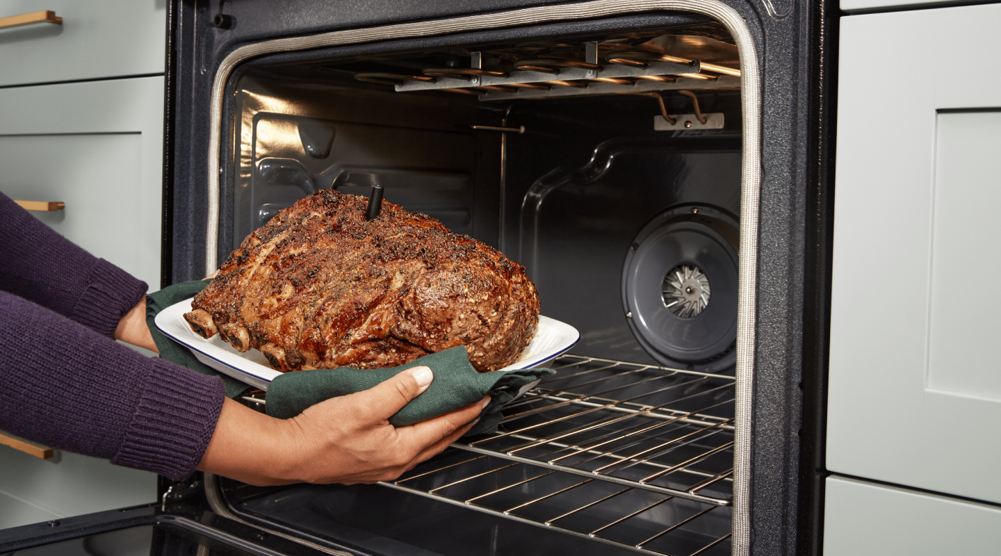 A person removing a roast from the oven. A person removing a roast from the oven.