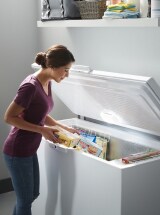 Person loading food into a standalone freezer