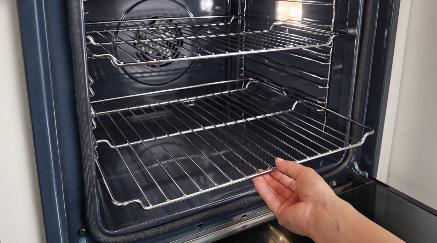Person removing an oven rack from a Whirlpool® oven Person removing an oven rack from a Whirlpool® oven