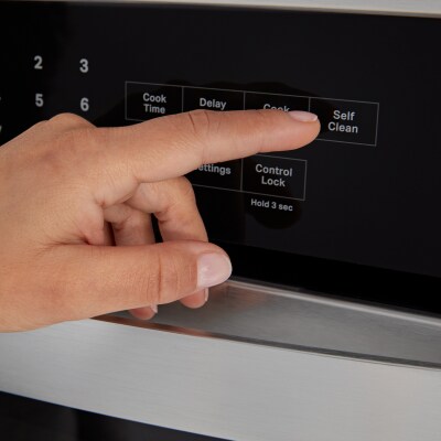 Person selecting a bake setting on a Whirlpool® oven
