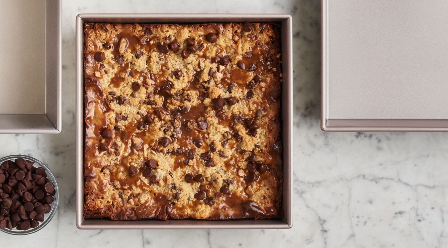 A square pan with a baked blondie brownie recipe on the inside A square pan with a baked blondie brownie recipe on the inside