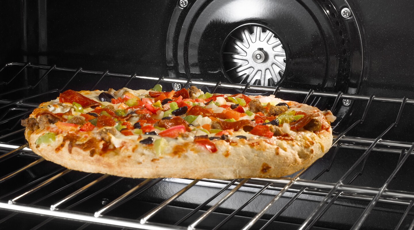 A flatbread pizza cooking in an oven A flatbread pizza cooking in an oven