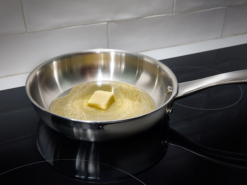 Butter melting in a pan on a cooktop