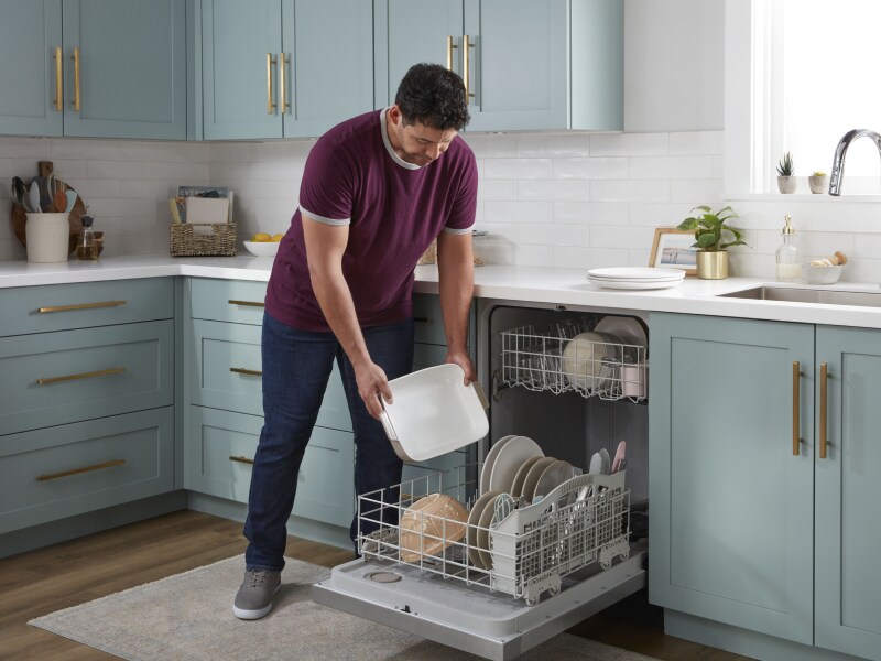 Person loading dishes into a dishwasher Person loading dishes into a dishwasher