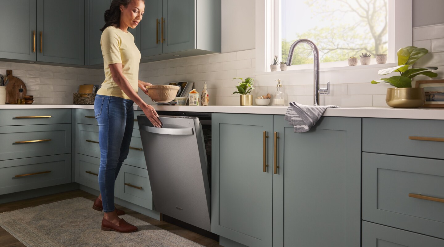 Person opening a stainless steel dishwasher Person opening a stainless steel dishwasher