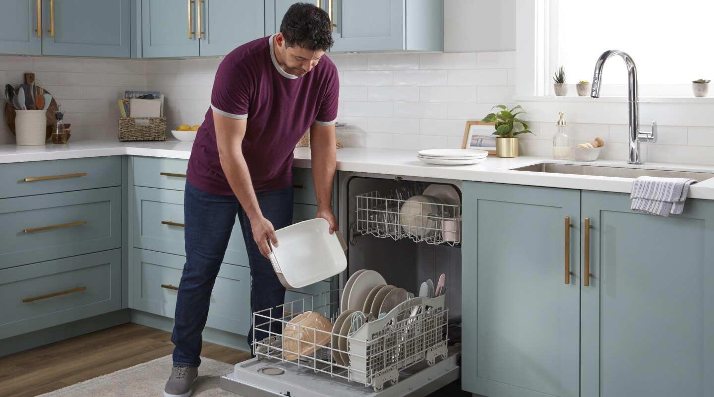 Person loading dishes into a dishwasher Person loading dishes into a dishwasher