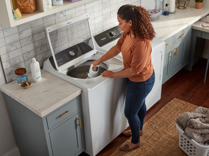 Person removing agitator from washing machine Person removing agitator from washing machine