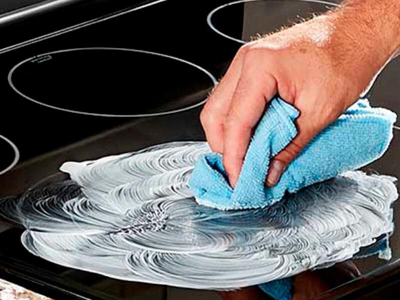 Person cleaning an electric stovetop