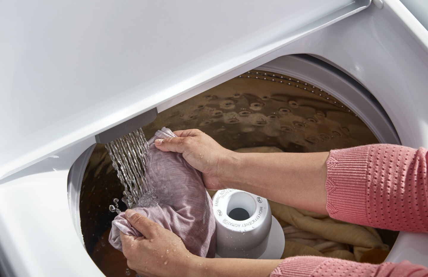 Person rinsing item in washing machine Person rinsing item in washing machine