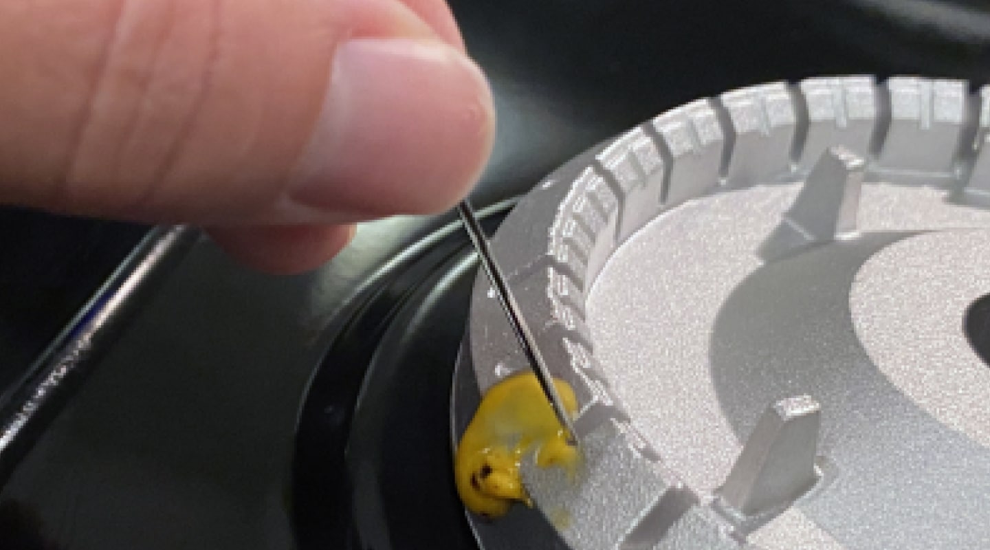 A person cleaning burner ports with a straight pin. A person cleaning burner ports with a straight pin.