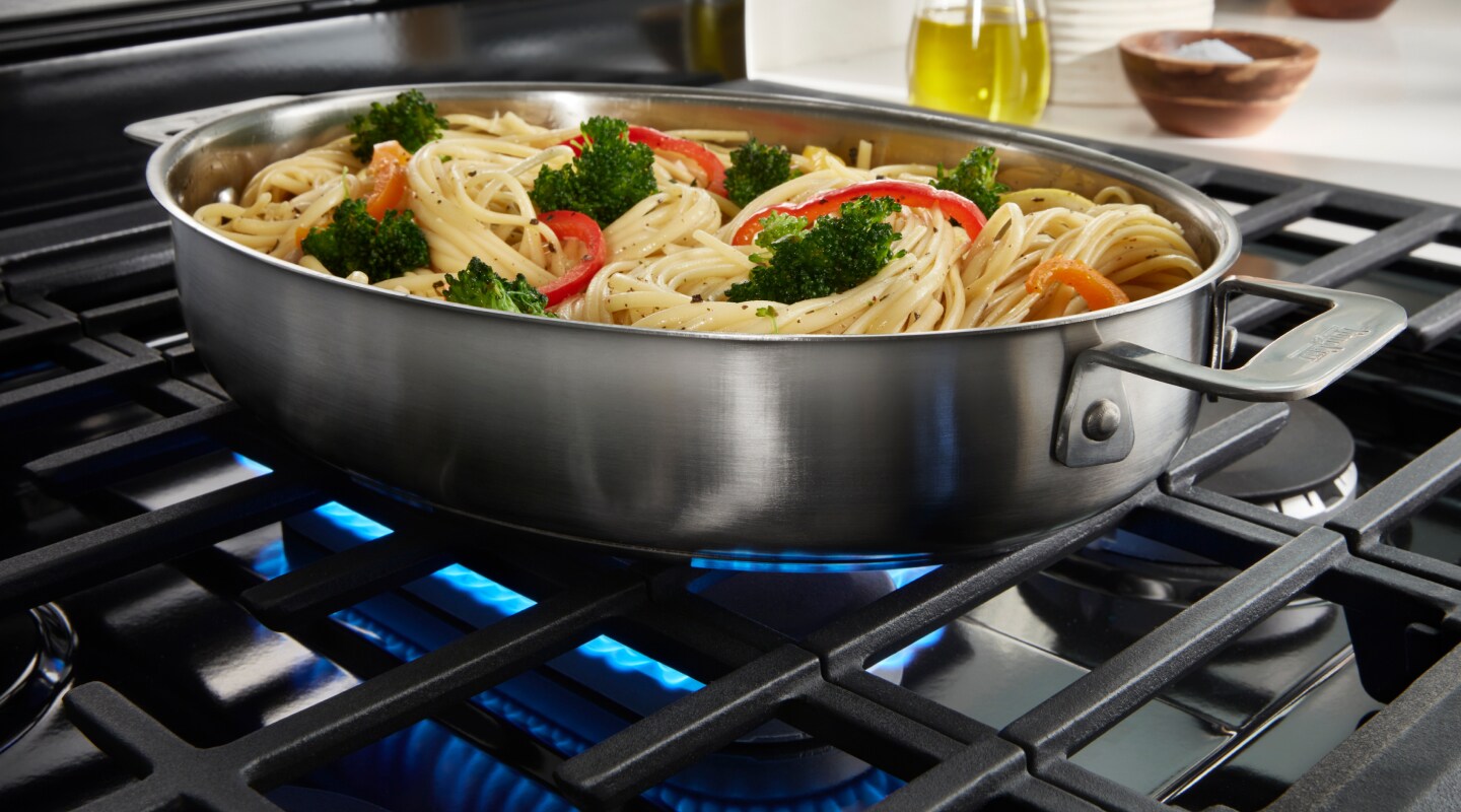 Spaghetti and vegetables cooking on a stovetop. Spaghetti and vegetables cooking on a stovetop.