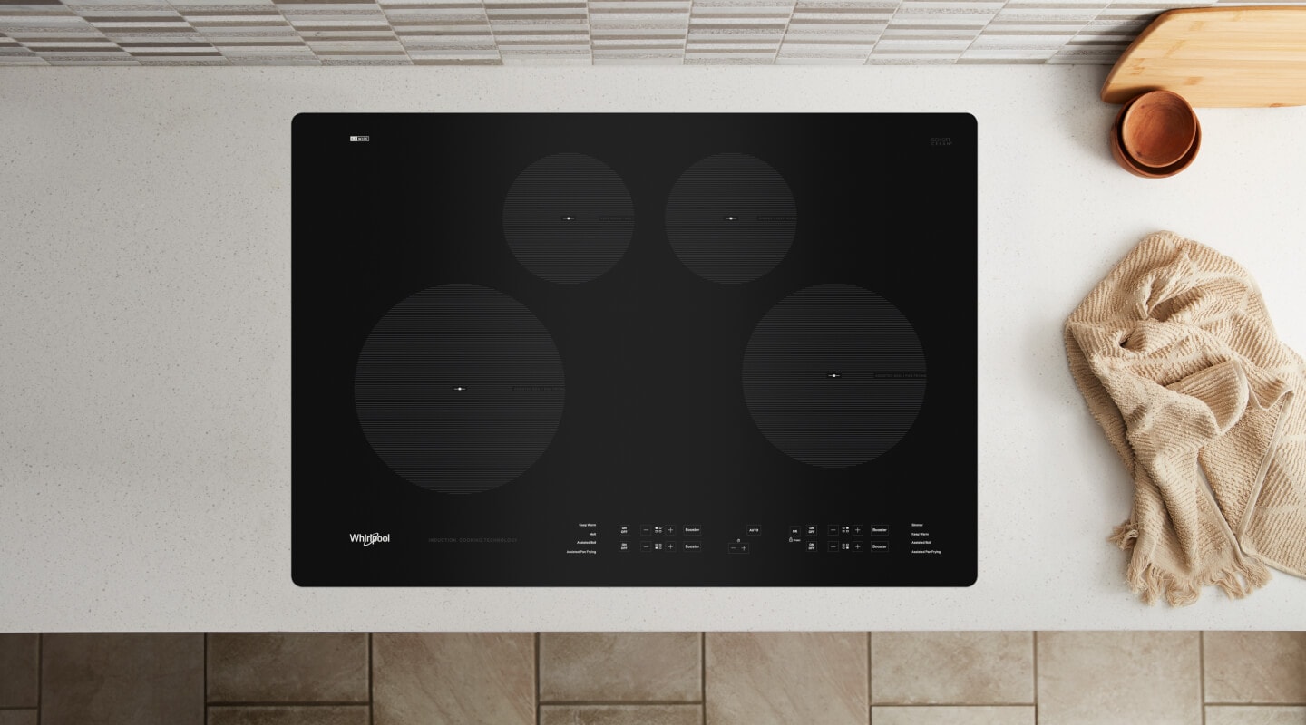 Birds-eye view of an induction stovetop built into a white countertop Birds-eye view of an induction stovetop built into a white countertop