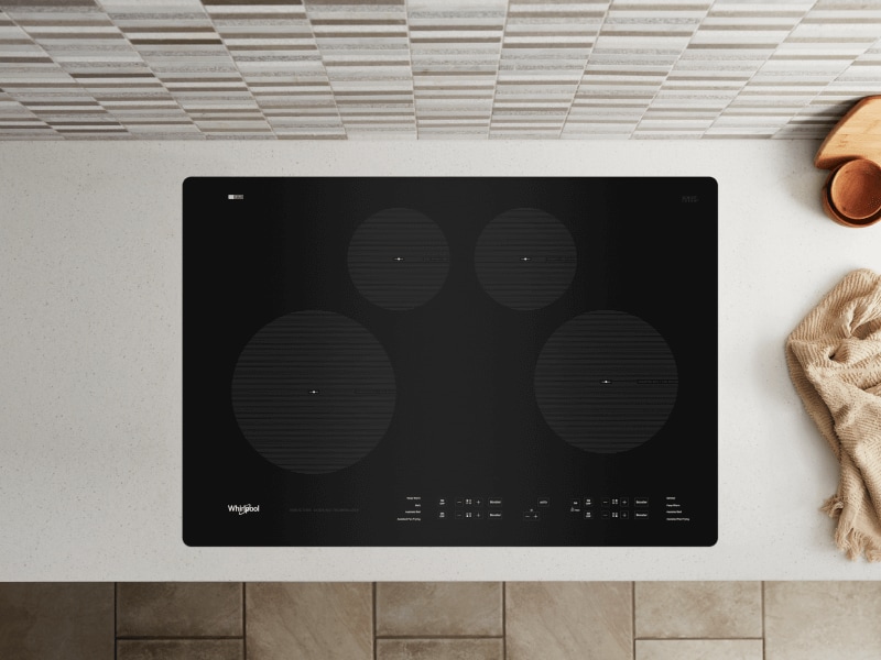 Birds-eye view of an induction stovetop built into a white countertop Birds-eye view of an induction stovetop built into a white countertop