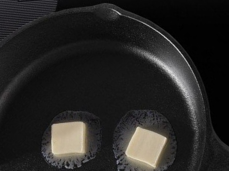 Cast iron skillet with melting butter inside Cast iron skillet with melting butter inside