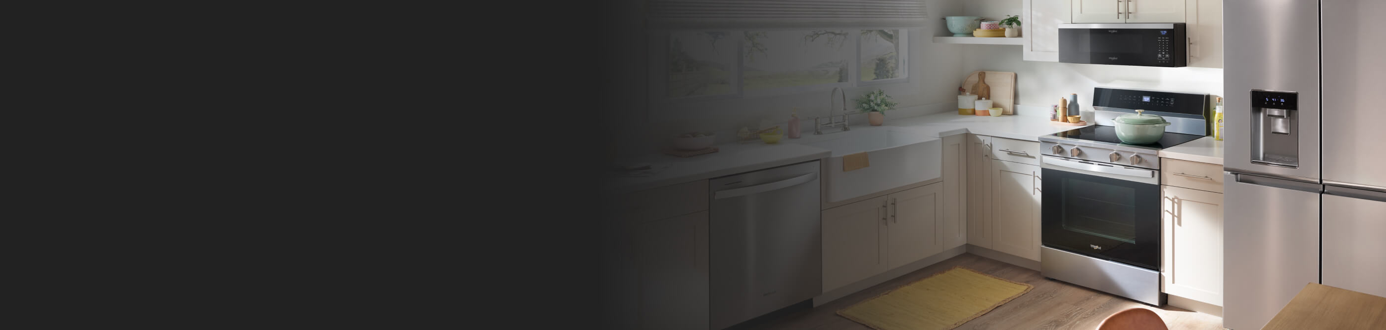  Interior shot of a kitchen with a stainless steel stove, microwave and refrigerator