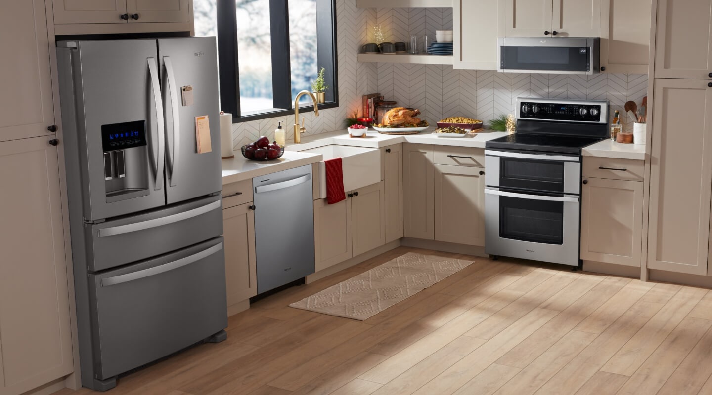 Interior shot of a kitchen with a stainless steel stove, microwave, refrigerator and dishwasher