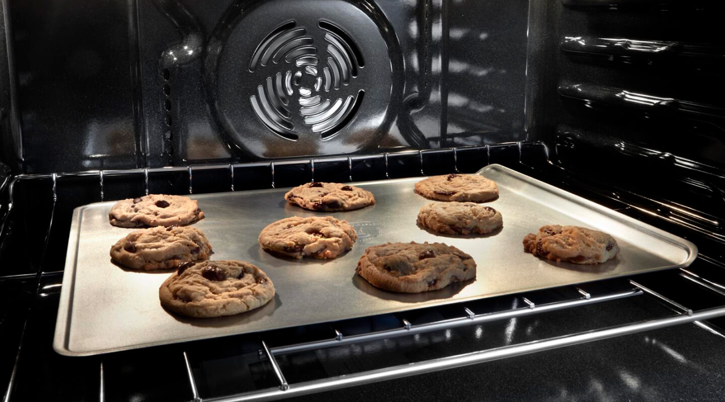 Chocolate chip cookies baking in an oven