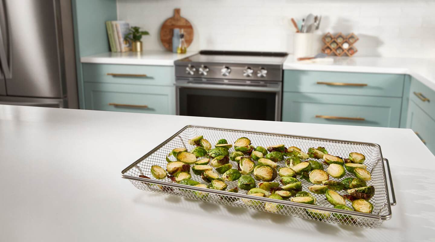 Sliced Brussels sprouts inside an air fryer basket
