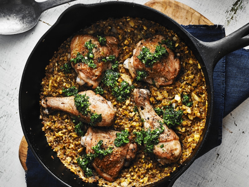 Cast iron skillet filled with baked chicken and rice medley Cast iron skillet filled with baked chicken and rice medley