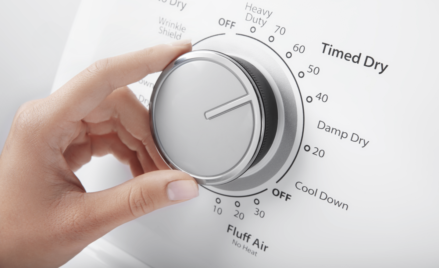 A person selecting dryer settings. A person selecting dryer settings.