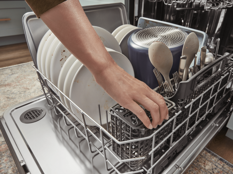 Person loading a dishwasher Person loading a dishwasher