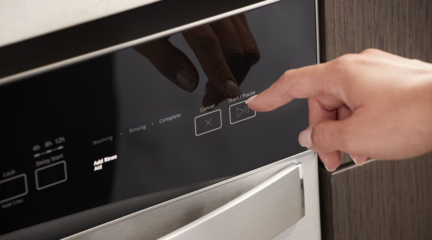 Person selecting a dishwasher wash cycle Person selecting a dishwasher wash cycle