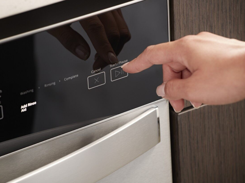 Person selecting a dishwasher wash cycle Person selecting a dishwasher wash cycle